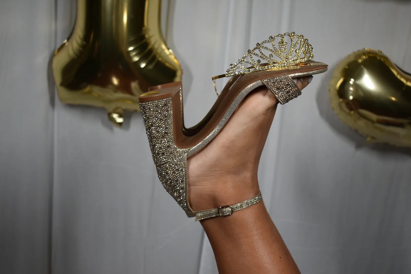 Detalle de la zapatilla dorada y la corona de Perlita