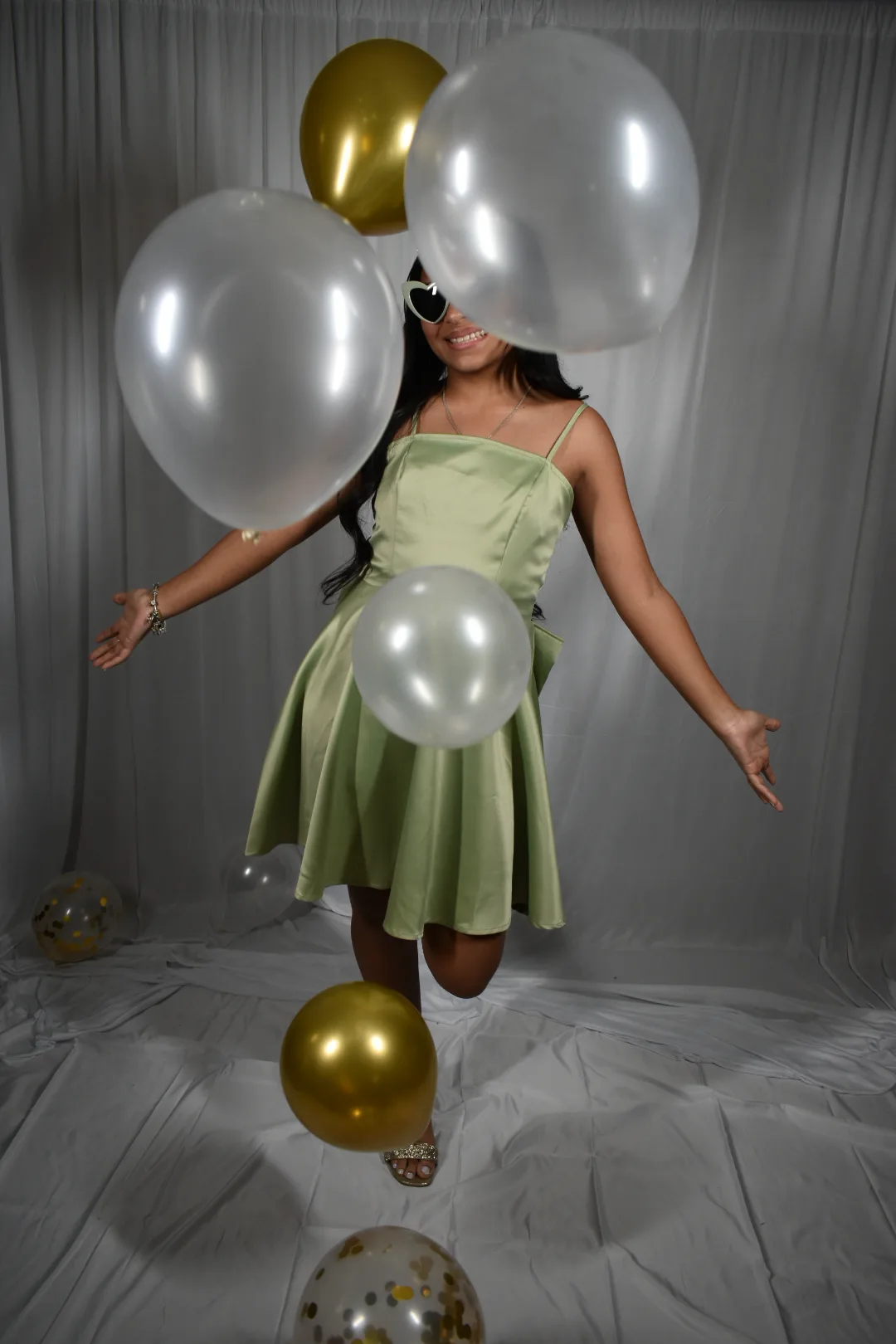 Perlita celebrando entre globos dorados y perla