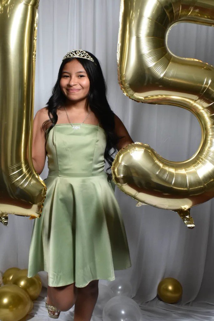 Perlita con su corona y los globos dorados de sus quince