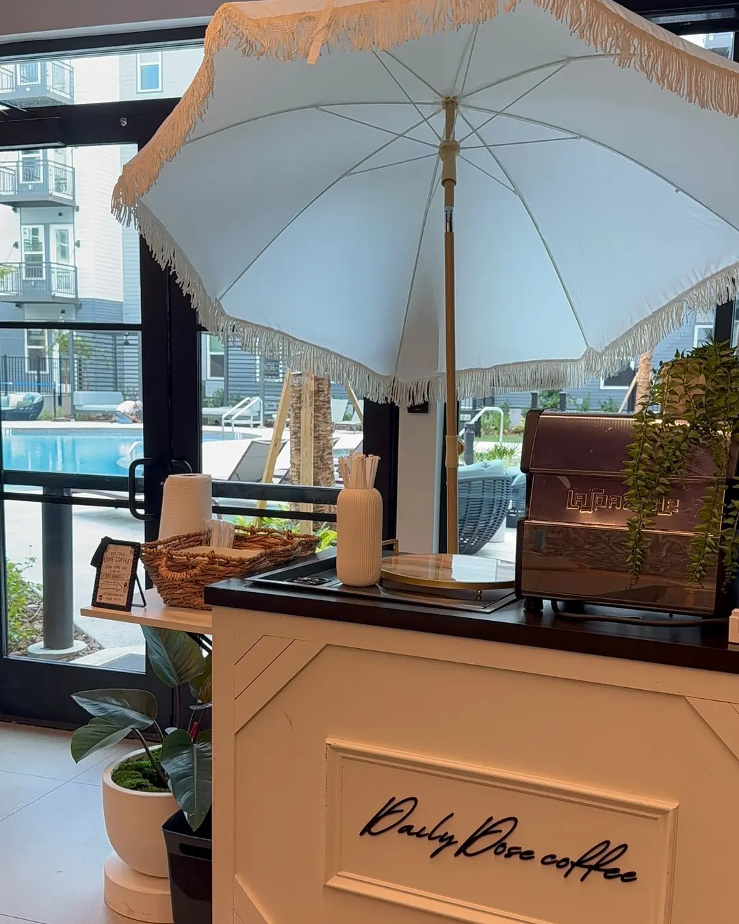 El carrito real de Daily Dose Coffee con su máquina de espresso bajo una sombrilla clara
